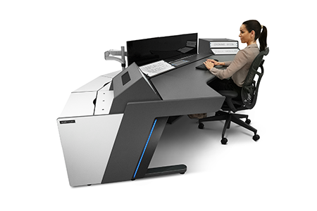 E-Type II Plus . A broadcast control room console, with a refined design. high-gloss piano black strip and compact laminate doors and panels providing easy access to stored equipment and cable management. The clear workspace creates an excellent user experience in any broadcast application. Shown in an ergonomic position by model.