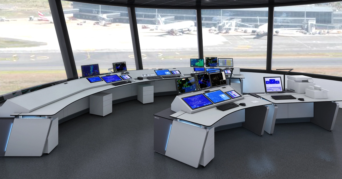 A modern air traffic control room with LundHalsey Air Traffic Control Room Consoles arranged in a U-shape, each equipped with multiple monitors displaying radar and flight data